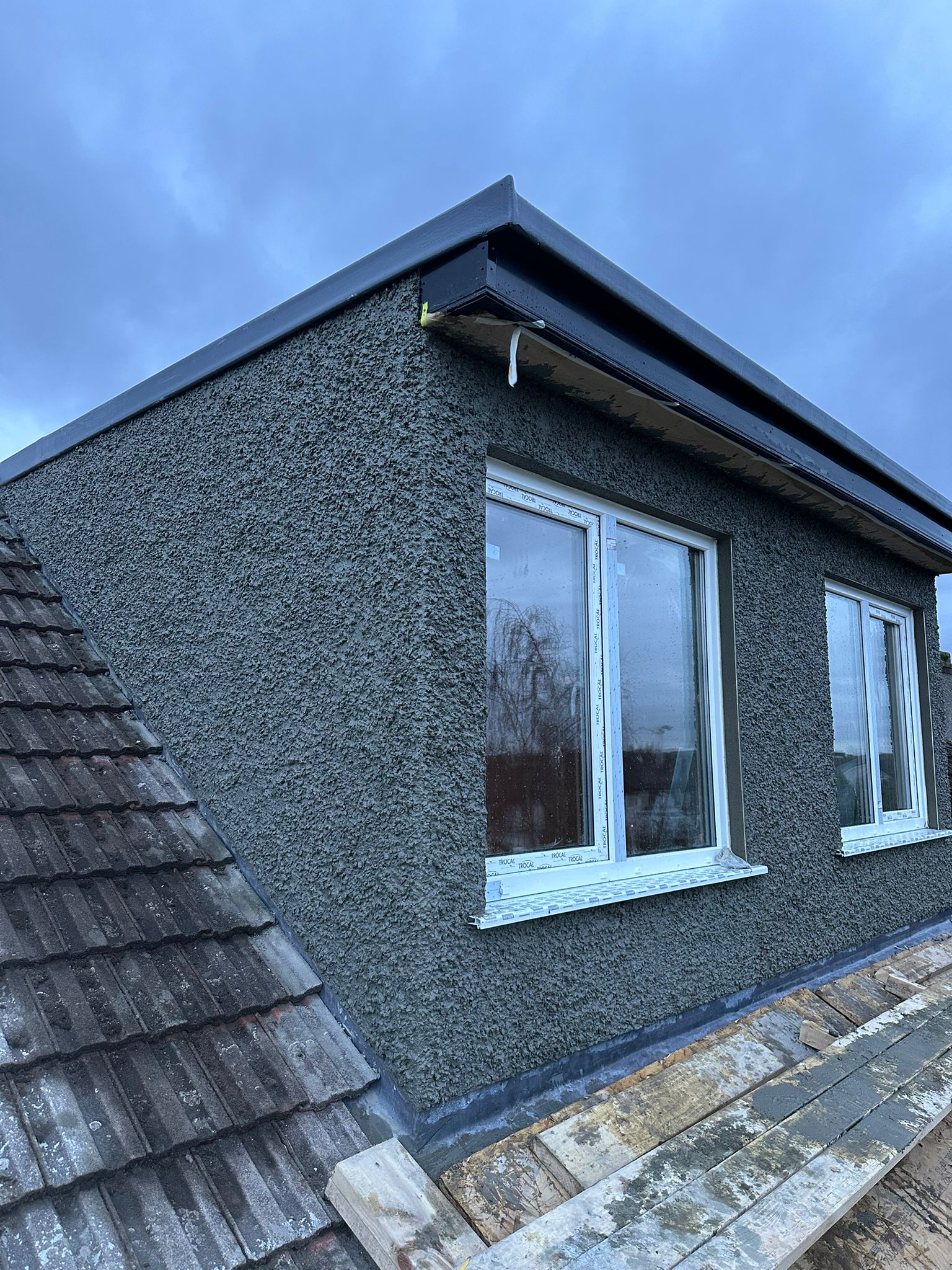 Dark pebbledash external rendering on gable wall by Causani Plastering Ireland