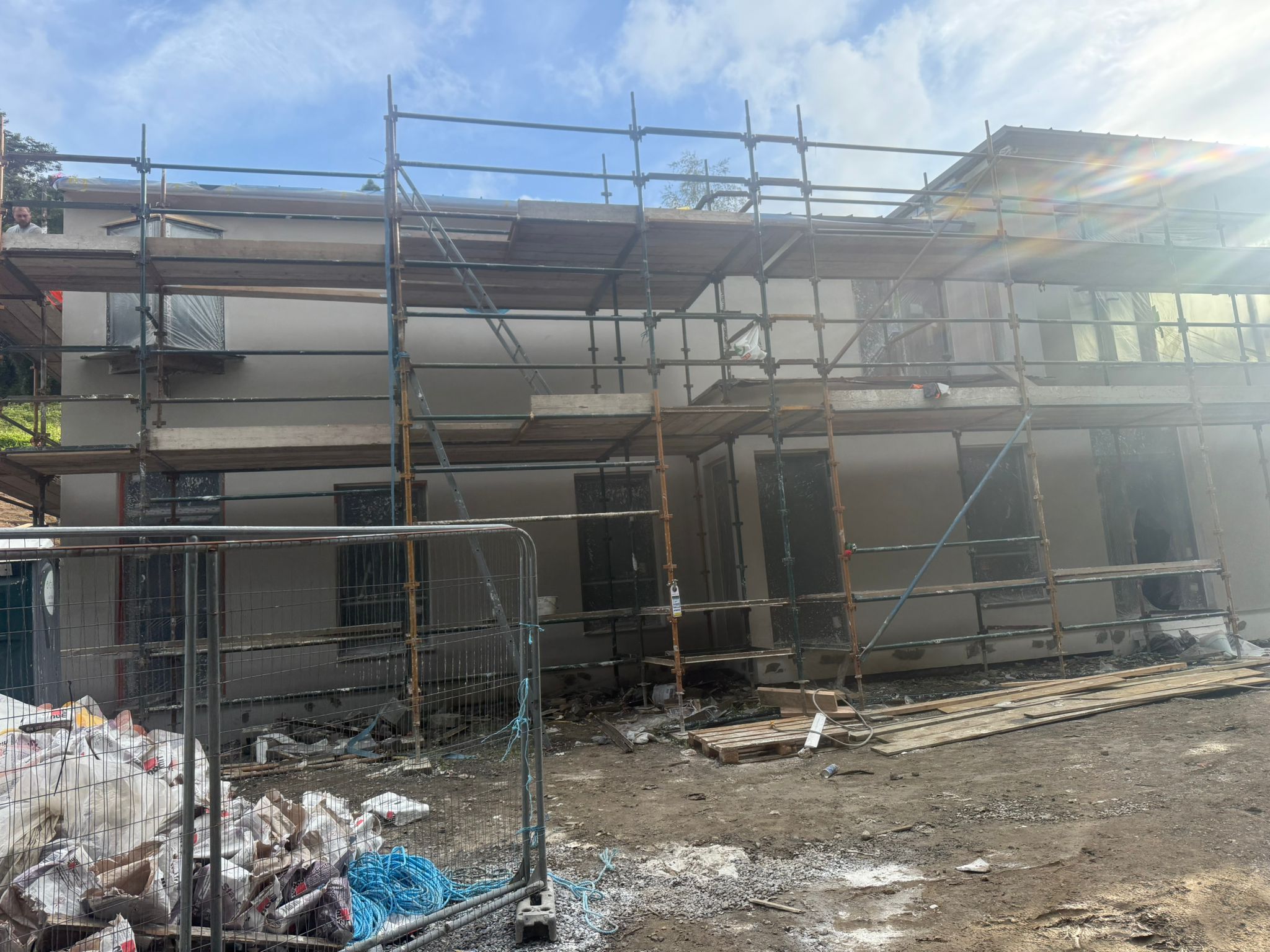 Large commercial building rendering in progress — Causani Plastering site team